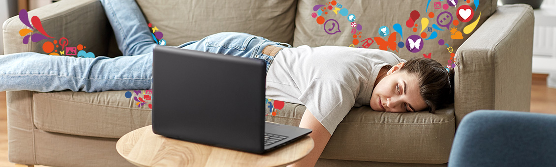 jeune étudiante allongé sur son canapé devant son ordinateur