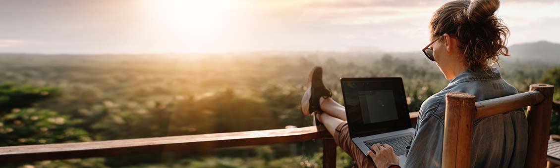 jeune femme avec un ordinateur portable face à un beau paysage